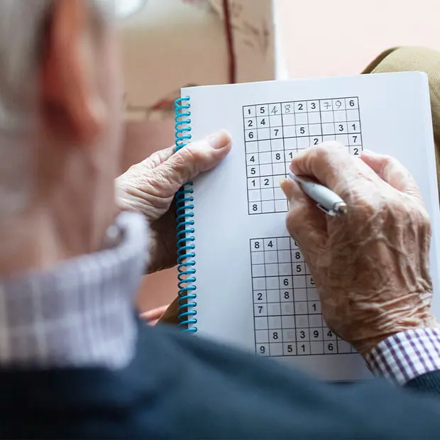 Alter Mann spielt Sudoku
