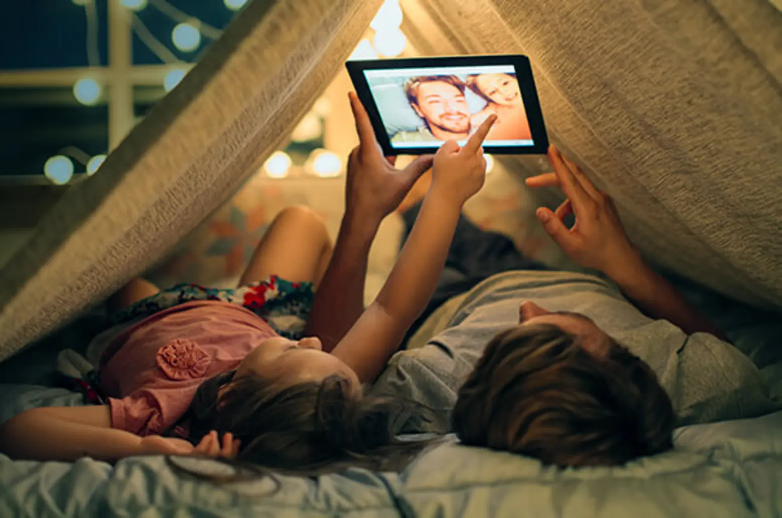 Vater und Tochter schauen auf Tablet